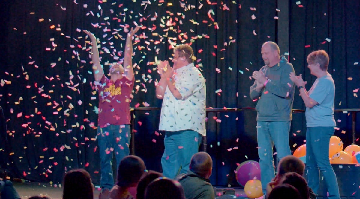 Contestants on stage celebrating in a confetti burst