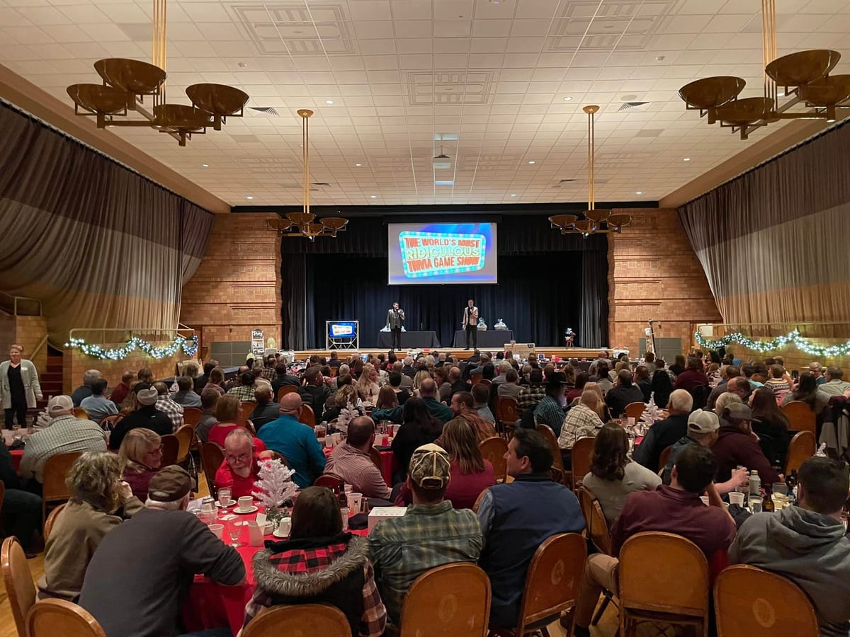 A packed hall watching the show on a big screen
